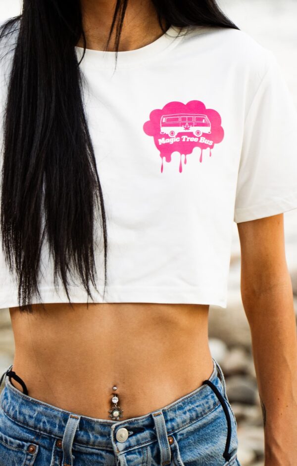 woman facing the camera wearing white crop top, magic tree bus logo in pink